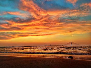 Scenic view of sea against dramatic sky during sunset