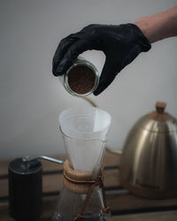 Close-up of hand pouring coffee cup