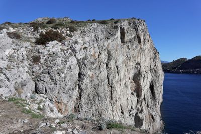 Rock formation on shore against sky