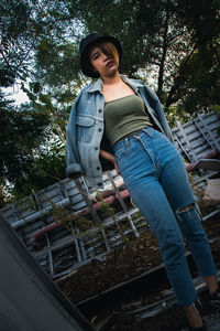 Portrait of woman standing by tree against plants