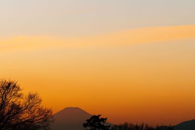 Scenic view of silhouette mountains against orange sky