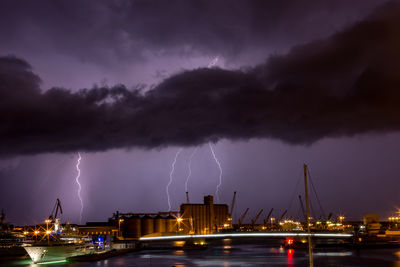 Panoramic view of lightning over sea against storm clouds