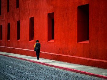 Full length of woman sitting on wall