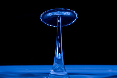 Close-up of water drop on glass against black background