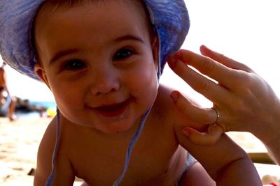 Close-up portrait of smiling baby boy at beach