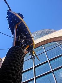 Low angle view of wooden post against clear blue sky