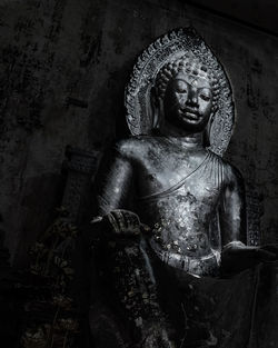 Statue of buddha against wall of building