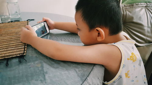 Boy using mobile phone at home