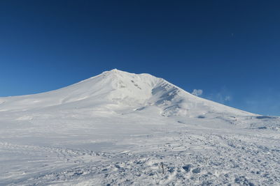 Scenic view of snowcapped mountains against clear blue sky