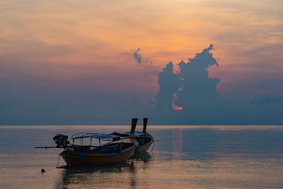 Boat in sea against sky during sunset