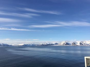 Scenic view of snowcapped mountains against blue sky