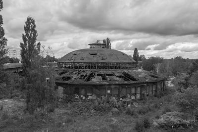 Abandoned building against cloudy sky