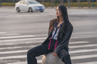 Young woman standing on road