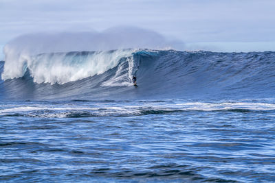 Man surfing on sea against sky