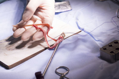 Cropped hand of doctor stitching human body part