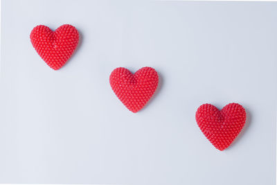 High angle view of red heart shape over white background