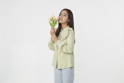 Young woman standing against white background