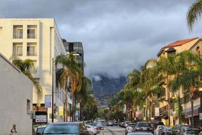 Cars on road against sky in city