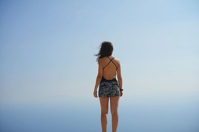 Rear view of woman standing against sky