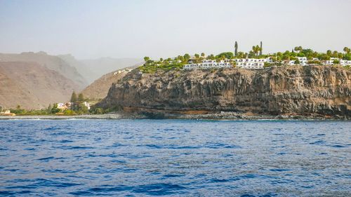 Scenic view of sea and mountain against sky