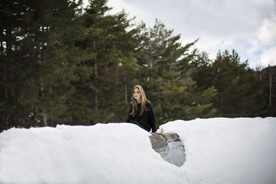 Portrait of young woman on snow covered land