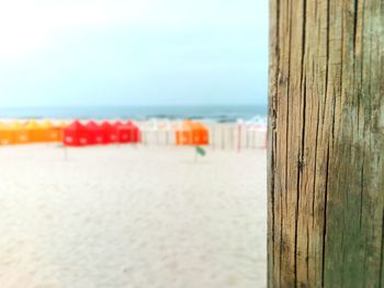 Wooden posts on beach against sky