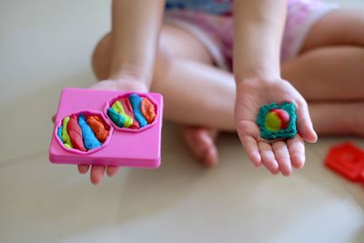 Midsection of woman holding multi colored candies