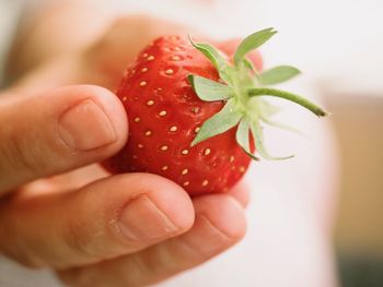 Close-up of hand holding strawberry