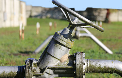 Close-up of pipeline on grassy field