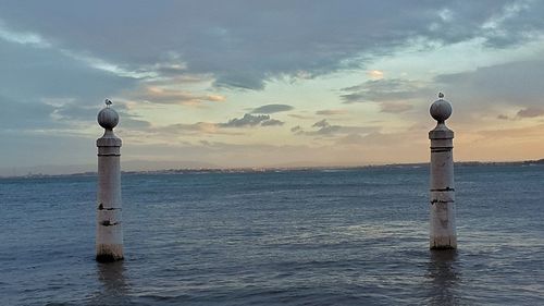 Lighthouse on sea against sky