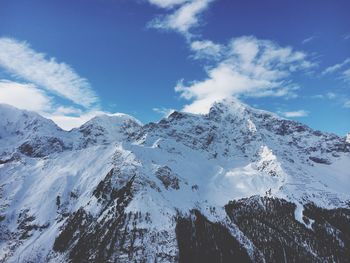 Low angle view of snow capped mountains against sky