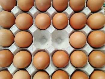 Full frame shot of brown eggs in crate