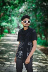 Portrait of young man wearing sunglasses standing outdoors