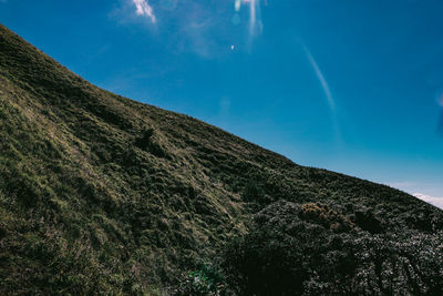 Low angle view of mountain against blue sky