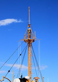 Low angle view of amusement park against blue sky