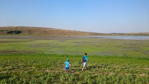 Rear view of man standing on grassy field