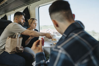 Family having lunch while sitting in train