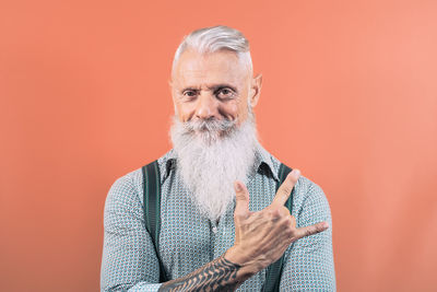 Portrait of man wearing hat against red background