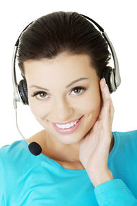 Close-up of young woman wearing headphones against white background