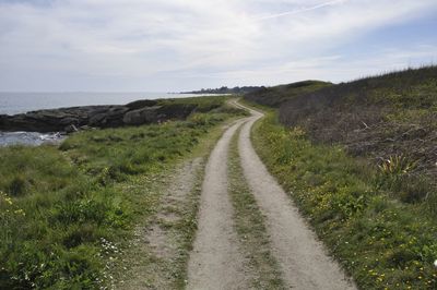 Road passing through landscape against sky