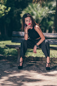 Woman sitting on bench in park