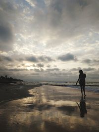 Mid adult woman standing on beach during sunset