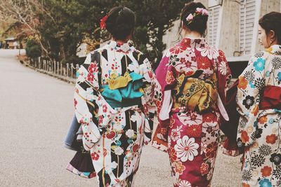 Rear view of women wearing kimonos while walking on street