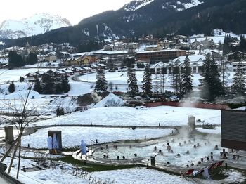 High angle view of snow covered houses by buildings in city