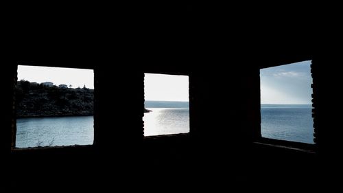 Silhouette of sea seen through window