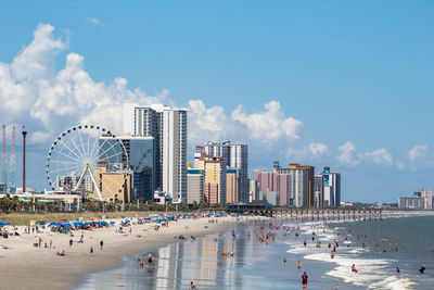 View of buildings at beach against cloudy sky