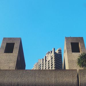 Low angle view of buildings against clear blue sky