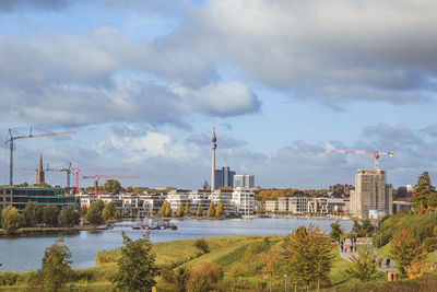 Buildings in city against cloudy sky