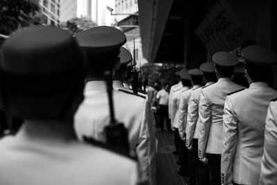 Rear view of soldiers marching on street 