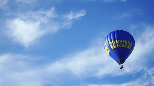 Low angle view of hot air balloon with text against sky